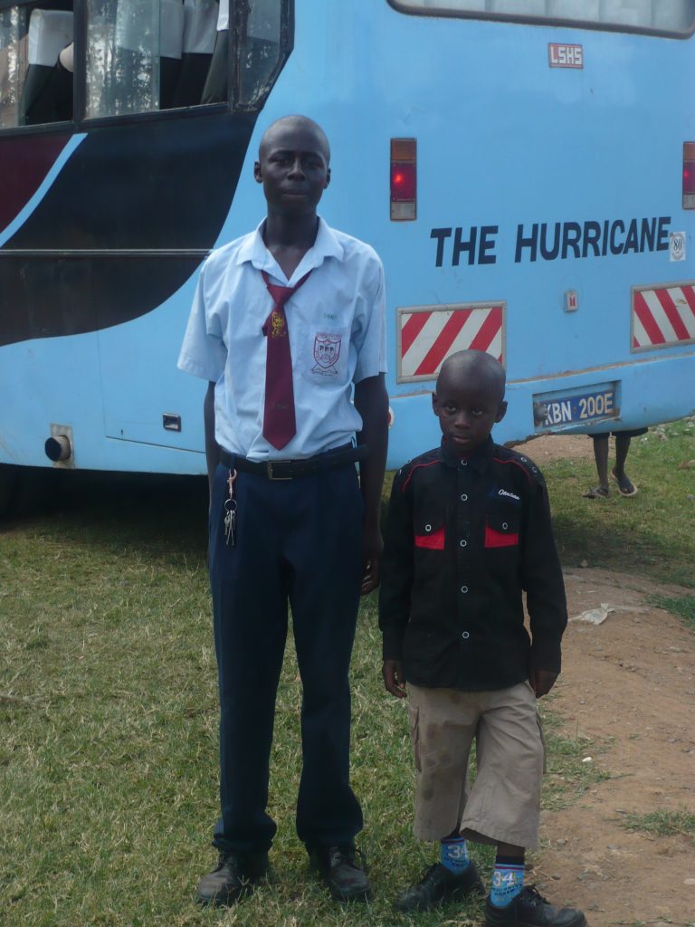 Michael in his school uniform with his younger brother Joseph Junior by the school bus